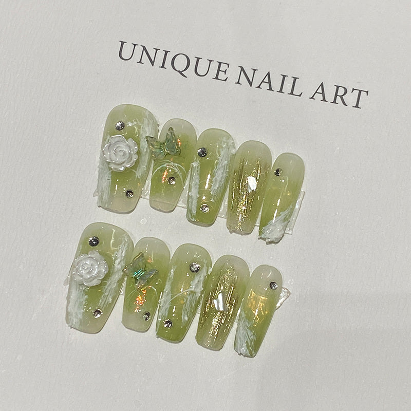 Grüne Farbe auf den Nägeln, um weiße Maniküre zu zeigen